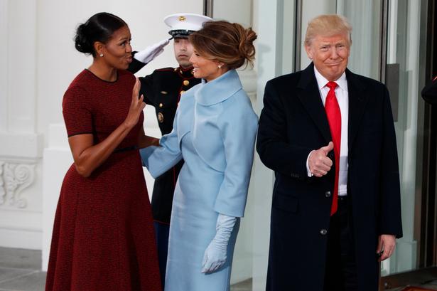Så kom de. Donald Trump hilser med en tommel op, mens Michelle Obama hilser på Melania Trump.
 