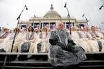 Medlemmer af koret Mormon Tabernacle Choir venter i regnen på scenen på Capitol Hill. 