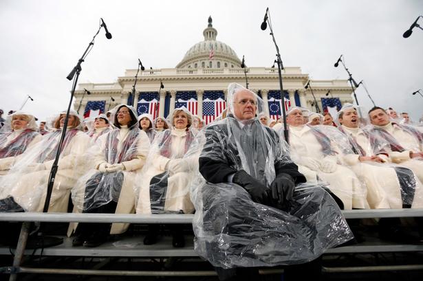 Medlemmer af koret Mormon Tabernacle Choir venter i regnen på scenen på Capitol Hill. 