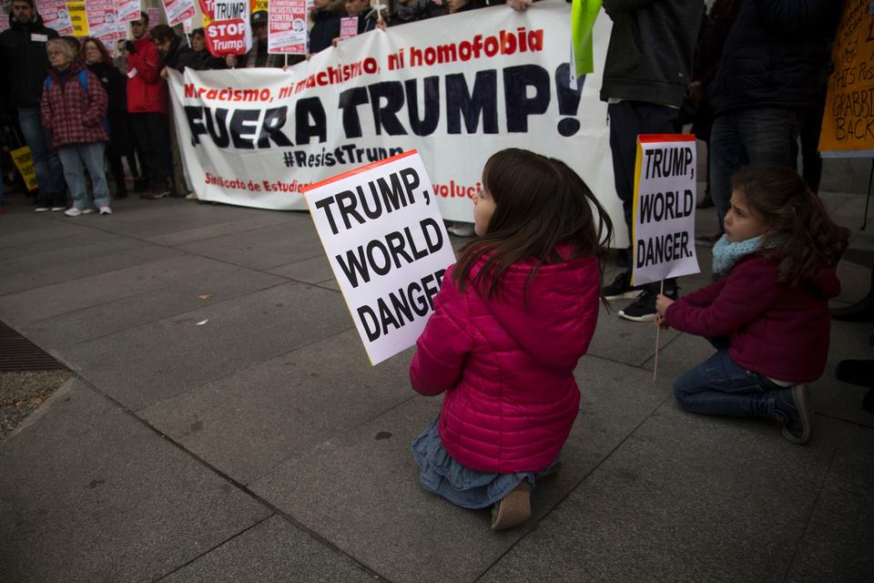 Uden for den amerikanske ambassade i Madrid mødte folk også op for at demonstrere. På banneret står der »Ingen racisme, ingen sexisme, ingen homofobi. Ud med Trump!«
 