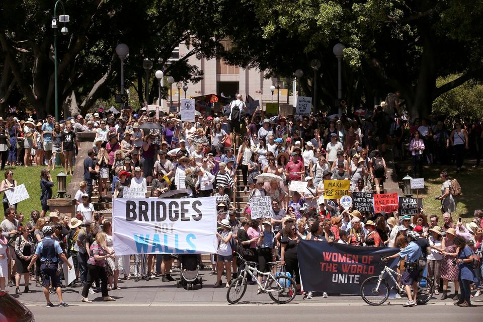 Foran Hyde Park i Sydney stimlede folk sammen for at deltage i demonstrationen. På bannerne står der blandt andet »Feminism is my trump card« og »Fight like a girl«. 