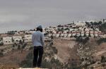 En jødisk bosætter kigger ud mod bosætterbyen Maaleh Adumim på Vestbredden.  