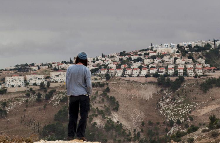 En jødisk bosætter kigger ud mod bosætterbyen Maaleh Adumim på Vestbredden.  