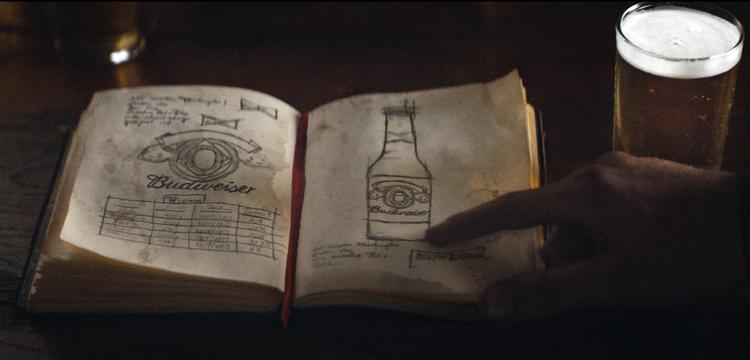 I den et minut lange Super Bowl-reklame, ser man, hvordan den ene af stifterne bag bryggeriet Anheuser-Busch, bliver budt velkommen af tilråd og skældsord, da han første gang ankommer til Amerika 