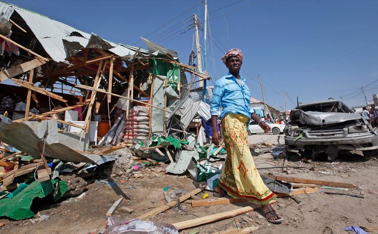 En mand passerer ødelagte boder og butikker på markedet i Mogadishu,  umiddelbart efter en bombe i en bil sprang of dræbte cirka 18 personer. 
 