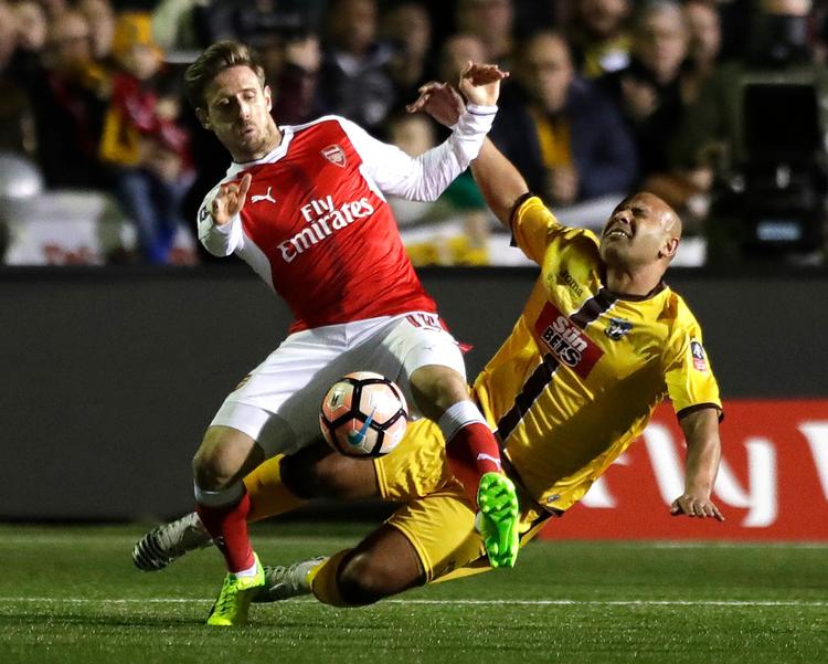 Arsenals Nacho Monreal (tv.) tackles af Suttons Nicky Bailey, der dog ser ud til at slå sig mest i situationen fra mandag aftens FA Cup-opgør. 