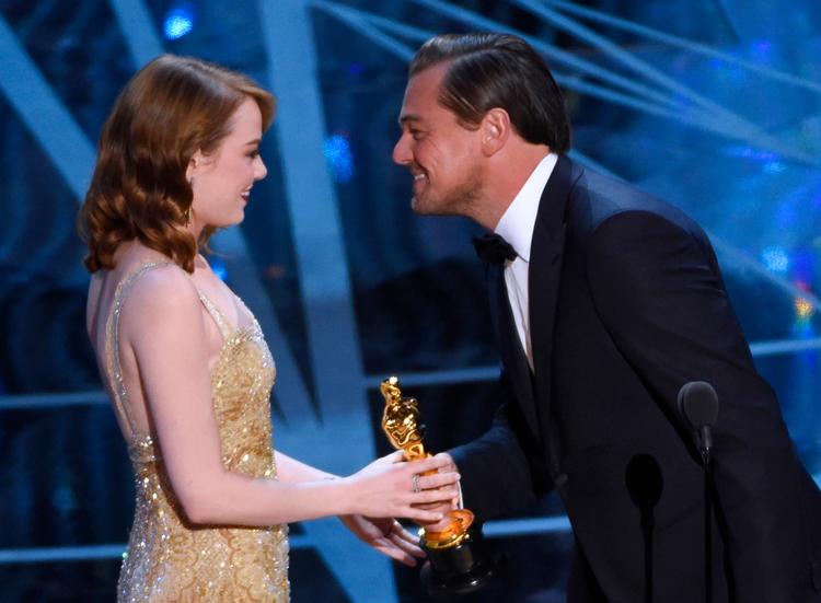 Leonardo DiCaprio, sidste års vinder af årets mandlige hovedrolle, overrækker prisen for bedste kvindelige hovedrolle til Emma Stone. 