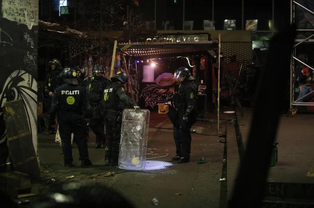 Inden for i bygningen. Politiets pressetalsmand Henrik Møller Jakobsen udtalte tidligere på aftenen, at man ville ransage huset, fordi der blev skudt med slangebøsse med møtrikker og kastet med flasker mod politiet, og fordi de kriminelle skulle drages til ansvar. Foto: Jacob Ehrbahn  