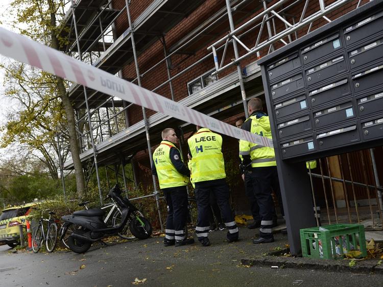 En læge og nogle reddere ved den opgang, hvor drabet fandt sted. 