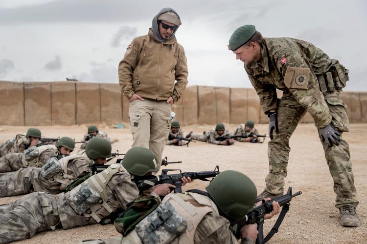 Medlemmerne af Jægerkorpset vil af sikkerhedsgrunde ikke fotograferes, her  instruerer en anden dansk soldat det irakiske grænsepoliti i skydning på Al Asad Air Base i Irak.
  