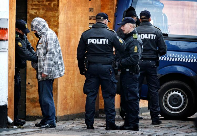 Et billede fra en retssag mod bandemedlemmer i Østre Landsret. Betjente sørger for sikkerheden blandt de besøgende. 