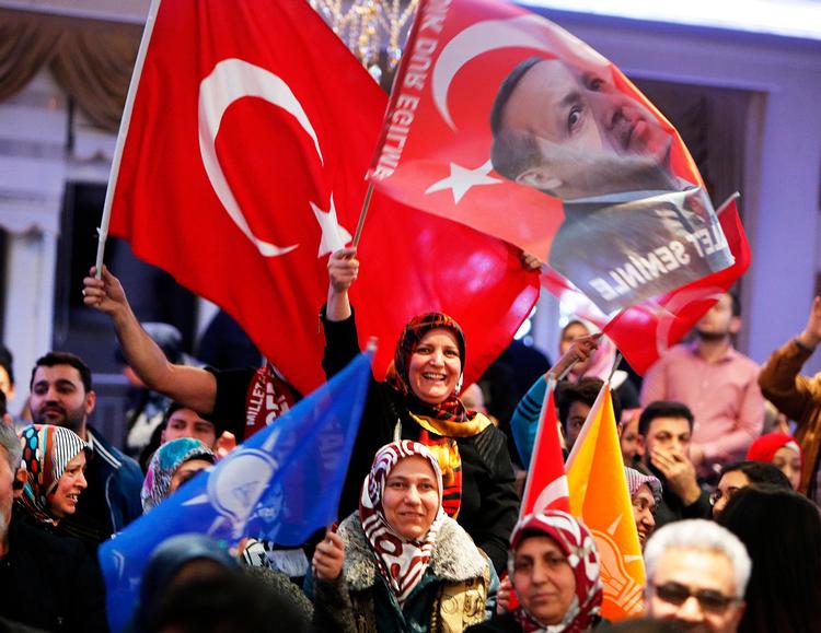 Kvinder flager med det tyrkiske flag og viser billeder af præsident Erdogan ved et valgmøde tæt på Frankfurt tidligere i denne måned. 