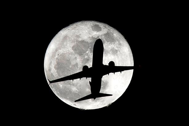 Et fly på vej til landing i Los Angeles Internationale lufthavn i silhouet foran en supermåne. 14. november, 2016. 