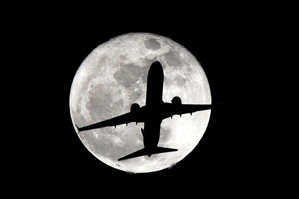 Et fly på vej til landing i Los Angeles Internationale lufthavn i silhouet foran en supermåne. 14. november, 2016. 