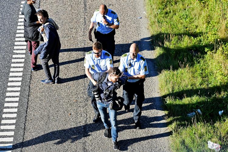 Her anholder politiet Politikens fotograf Martin Lehmann, mens flygtninge vandrer på de danske motorveje i 2015. Ernst Van Norde/POLFOTO