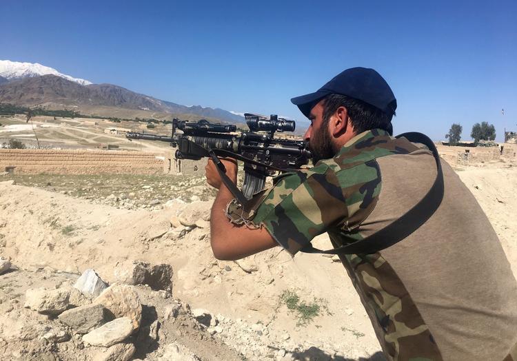 En afghansk vagt står klar i landsbyen Pandola tæt ved målet for det amerikanske angreb. 