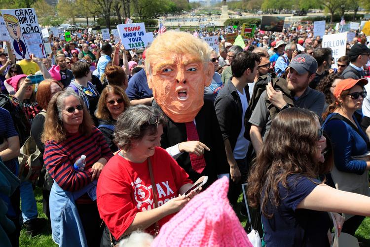 Den største demonstration mod Trump finder sted i Washington, hvor deltagere bærer plakater med påskrifter som 'Hvad er det, han gemmer?' og 'Rigtige mænd betaler deres skat' 
