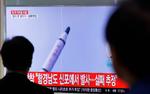 Sydkoreanere kigger på billeder af en nordkoreansk missilaffyring. 