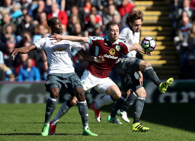 Burnleys Ashley Barnes omringet af Manchester United-spillerne Paul Pogba og Daley Blind på Turf Moor søndag eftermiddag.
 