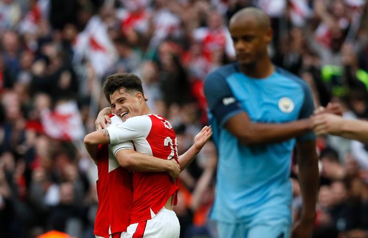 Arsenals Granit Xhaka omfavner Laurent Koscielny, mens Manchester Citys Vincent Kompany ærgrer sig over nederlaget på Wembley.
 
