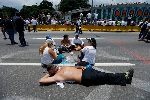 Demonstranter tager det roligt under en blokade af en hovedvej i Caracas. 
