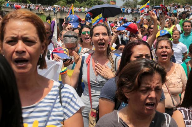 Tusindvis af demonstranter råber slagsange vendt mod præsidenten, mens de blokerer en hovedvej i Caracas. 