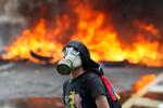Mindst 24 mennesker er dræbt og mange sårede under voldsomme demonstrationer i Venezuela. Her en demonstrant foran en brændende barrikade i Caracas, Venezuela.  