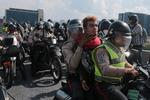Anholdte demonstranter køres væk på politimotorcykler. 