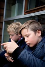 Sebastian og Villads, der går i 4. klasse, hiver straks deres mobiler frem, når de får lov til det. Der er mange opgaver for forældrene, når deres børn begynder at bruge mobilen, mener forsker.
 