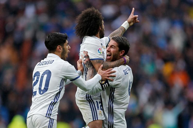 Real Madrids lørdagshelt Marcelo fejres af sine holdkammerater, og brasilianerens 2-1-træffer kan blive afgørende for kampen om den spanske titel. 