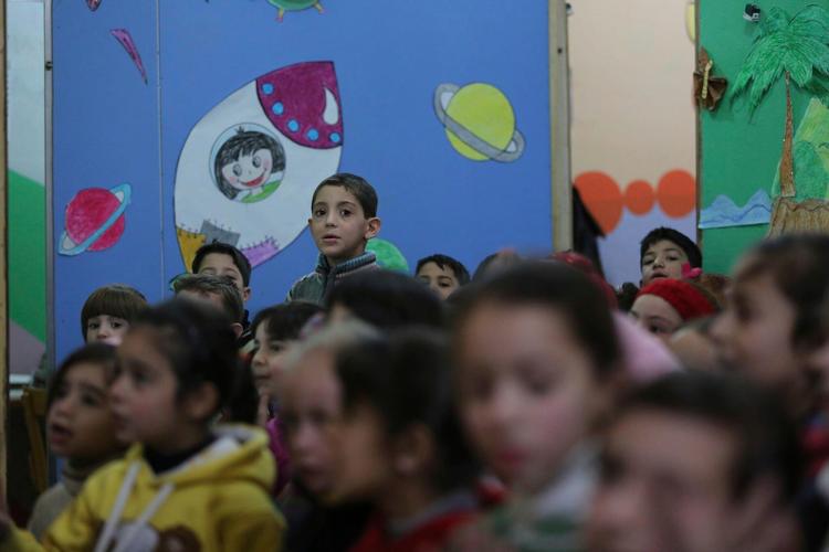 Syrien er et af de 26 lande i krig eller konflikt, hvor mindst en af parterne har inddraget skoler, både med og uden børn, i den væbnede konflikt. Her venter børn i Damaskusforstaden Ghouta, Syrien, på at komme til time. Foto: Al-Shami/ UNICEF via AP  