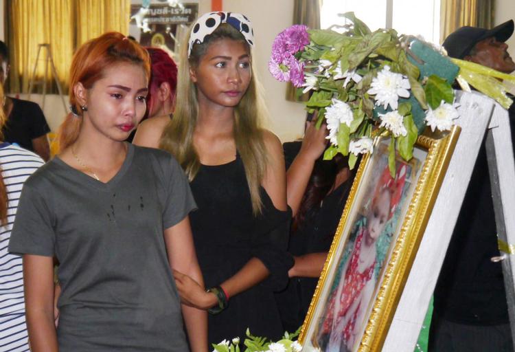 Moderen (tv) til den 11 måneder gamle baby, der blev dræbt af sin far på Facebook Live, sørger foran et portræt af datteren ved begravelsen i Phuket i det sydlige Thailand.  
