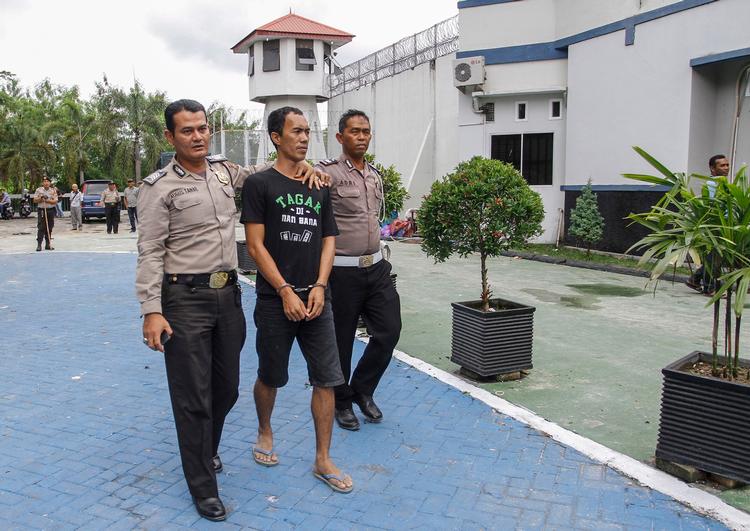 Indonesiske betjente med en af de fanger, som stak af.  