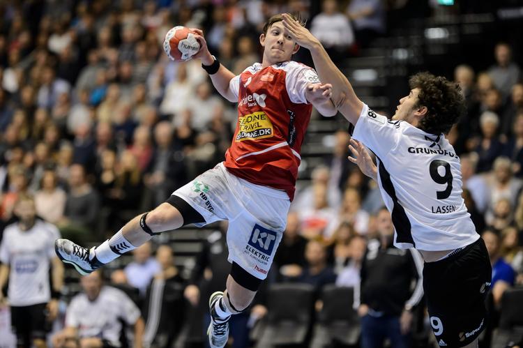 Den norske stjerne Sander Sagosen er steget til vejrs i hjemmekampen mod BSV, og Jacob Lassen forsøger at sætte en tackling ind.  