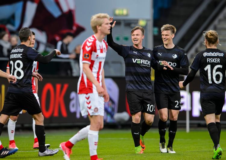 Marvin Pourié jubler med Randers-holdkammaraterne, mens AaB's spillere slæber sig mod midten af banen. 