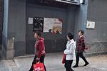 Lokale i centrum af Beijing går forbi en mur, hvor plakaten i midten opfordrer dem til at være på udkig efter spioner. 