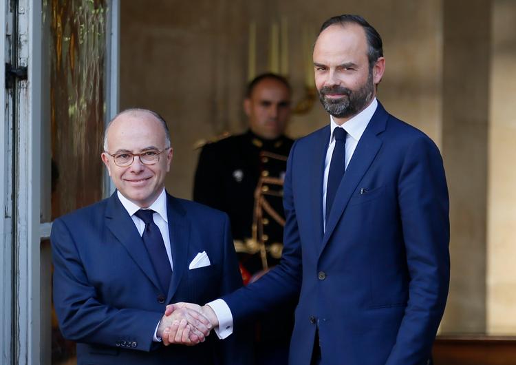 Den nyudpegede regeringschef Édouard Philippe (th.) giver hånd til tidligere  premierpræsident  Bernard Cazeneuve. 