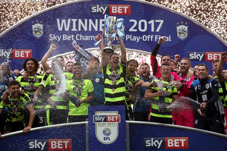 Anfører Mark Hudson med trofæet som bevis på, at Huddersfield har vundet playoffkampen om en plads i Premier League. 