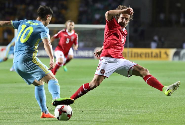 Kasakhstans Georgi Zhukov forsøger at få bolden forbi Danmarks Thomas Delaney på Almaty Ortalyk Stadion lørdag aften. 