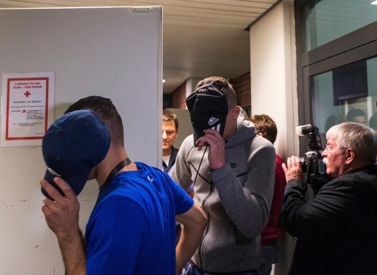 To af de unge asylansøgere ankommer til retten i Berlin, skjult bag deres kasketter. De unge var mellem 15 og 21 år. 