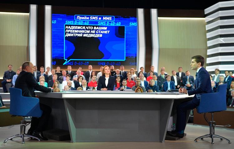 »Lad os håbe, at Deres efterfølger ikke bliver Dmitrij Medvedev«, lyder sms-beskeden gengivet bag Putin i mandagens transmission på russisk stats-tv.

Russian President Vladimir Putin, left, speaks with TV hosts, during his annual televised call-in show in Moscow on Thursday, June 15, 2017. (Alexei Druzhinin/Sputnik, Kremlin Pool Photo via AP) 