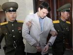 En synlig dårlig Otto Warmbier mellem to nordkoreanske soldater. 
