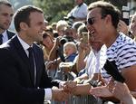 Macron hilser på vælgerne efter at have afgivet sin stemme. 