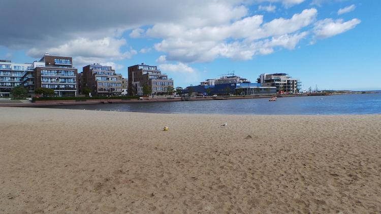 Stranden i Kristiansand i Norge ser måske ikke ud af meget, men den er verdens dyreste, hvis man skal købe sololie og have noget at spise og drikke. 