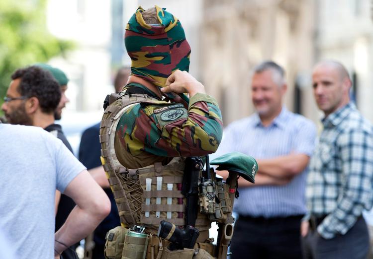 Belgisk soldat justerer sin ansigtsmaske. Han patruljerer foran premierministerens kontor dagen efter et bombeangreb på banegården.   