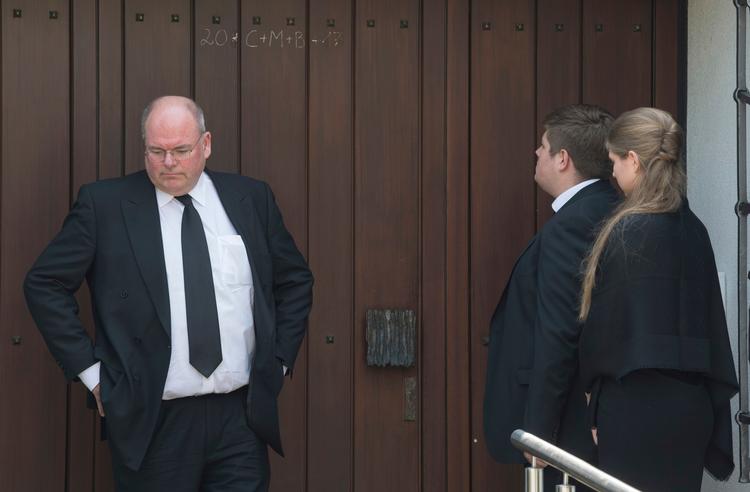 Walter Kohl venter sammen med sine to børn udenfor sit barndomshjem, hvor hans far, ekskansler Helmut Kohl, døde forleden. 