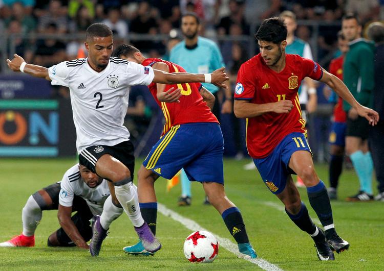 Den spanske Real Madrid-spiller Marco Asensio (th.) forsøger her at spille sig fri af Tysklands Jeremy Toljan under U21-finalen fredag i Polen.  
   