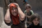 En kvinde skriger, mens hun flygter med sin familie gennem en sønderskudt gade i Mosul tidligere i dag.  