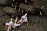 Modige - eller dumdristige - løbere flygter fra de løsslupne tyre i Pamplonas gader til den årlige San Fermin Festival.    