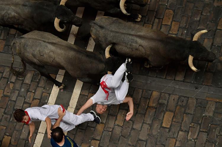 Modige - eller dumdristige - løbere flygter fra de løsslupne tyre i Pamplonas gader til den årlige San Fermin Festival.    